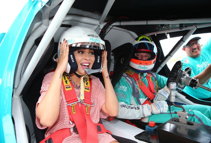 Alinne Rosa tenta soltar a voz no banco do carona de Rubens Barrichello (Foto: Divulgação)