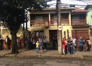 Vizinhos de Patrícia Moreira observam casa que foi incendiada (Foto: Paula Menezes/GloboEsporte.com)