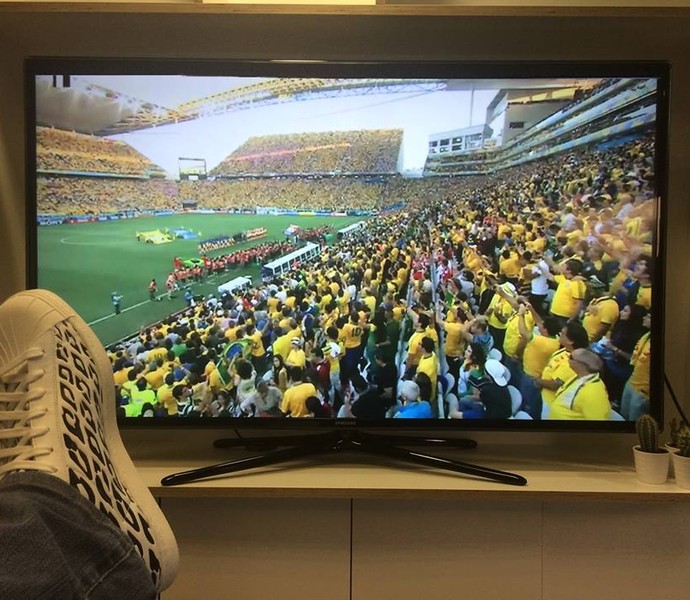 Messi com as pernas para cima acompanhando o jogo entre Brasil e Argentina (Foto: Reprodução/Facebook)