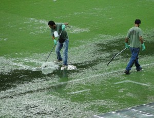 Funcionários da Minas Arena tiram água do campo com rodo no Mineirão (Foto: Tarcísio Badaró)