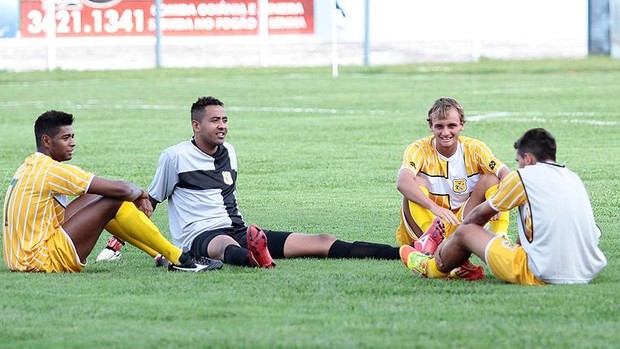 Jogadores do Brasiliense sentados no gramado. Jogo adiado por falta de policiamento (Foto: Cláudio Bispo - Brasiliense divulgação)