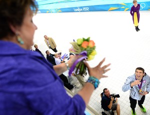 Michael Phelps joga flores para sua mãe após 4x100m medley nos Jogos de Londres (Foto: Christophe Simon/AFP)