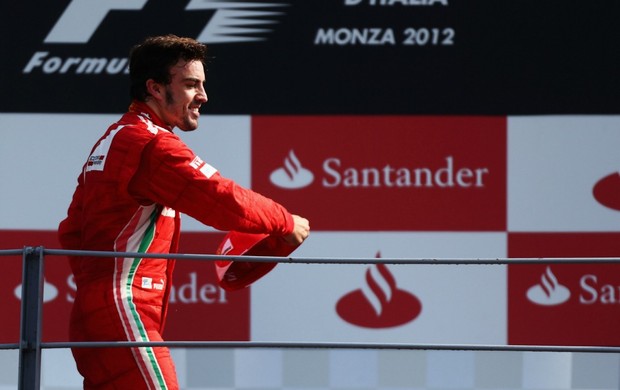 Fernando Alonso joga o boné para a torcida no pódio em Monza (Foto: Getty Images)