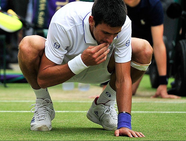 tênis djokovic come grama wimbledon (Foto: agência AFP)