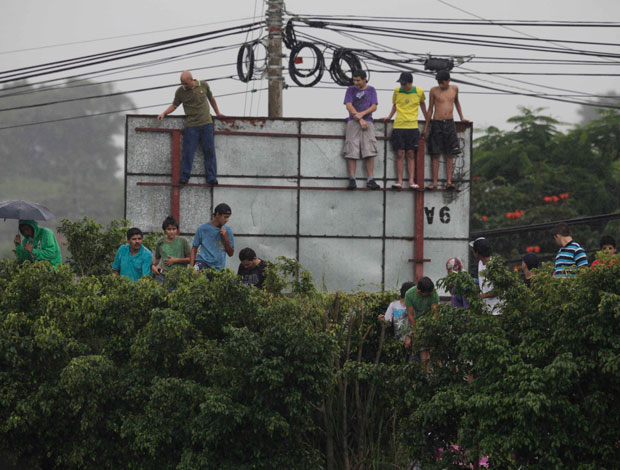 Torcedores sobem em placa para ver o treino da seleção brasileira (Foto: Mowa Press)