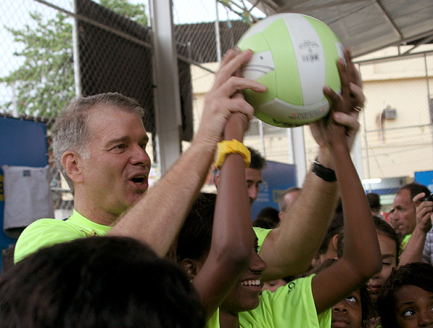 Bernardinho ensina menina a sacar em escolinha de vôlei no Complexo do Alemão (Foto: Pedro Veríssimo/Globoesporte.com)