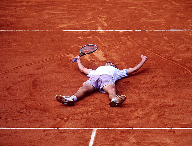 Guga deitado em Roland garros comemorando título (Foto: Getty Images)